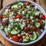 Greek Bean Salad with Lemon Marinated Beans, featuring crisp cucumbers, juicy tomatoes, olives, and fresh herbs in a zesty dressing.
