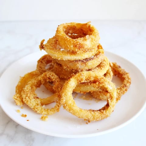 Crispy, golden onion rings coated in a light, flavorful batter and deep-fried to perfection—an irresistible appetizer or snack. 