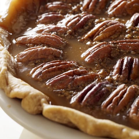 Freshly baked Southern pecan pie with a golden, flaky crust and caramelized filling.