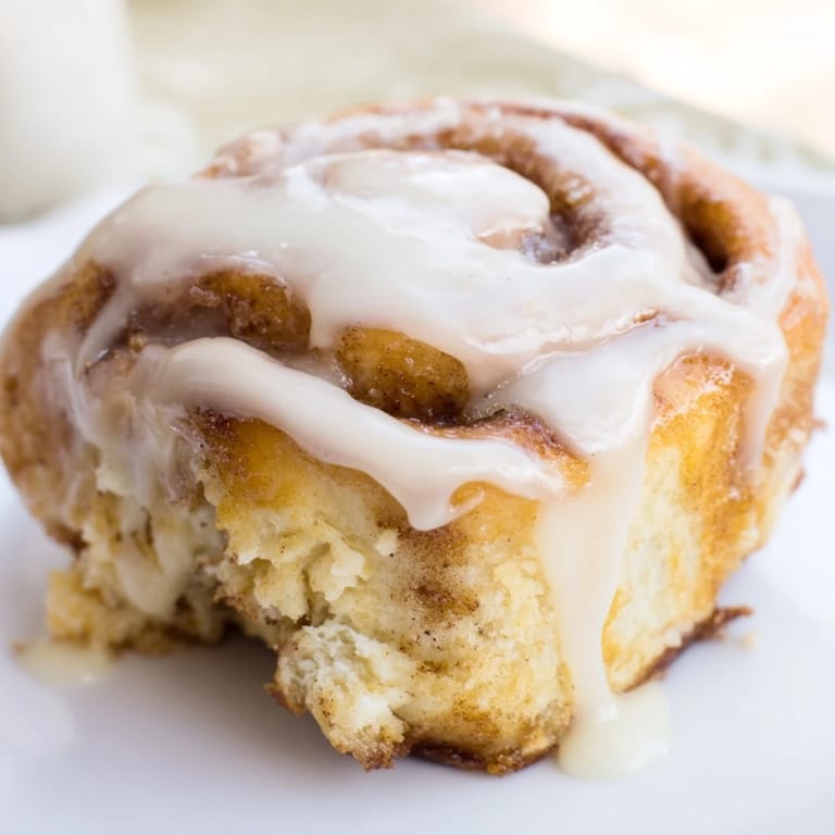 Homemade Cinnamon Rolls arranged on a white plate, showing fluffy layers and a sweet glaze, perfect for a cozy brunch.