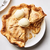 Freshly baked Apple Pie with a golden lattice crust and warm, spiced apple filling, ready to serve with vanilla ice cream.